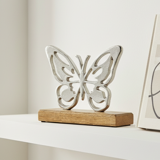 Silver butterfly on white shelf with book